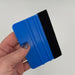 Blue 4-inch felt-edge decal squeegee held in hand for scale